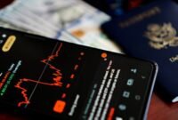 Seorang investor tersenyum sembari melihat grafik pertumbuhan dividen di aplikasi investasi, menggambarkan kegembiraan saat menerima aliran dana tunai dari keuntungan perusahaan. Pemandangan ini merefleksikan optimisme pasar modal terhadap musim panen dividen yang sedang berlangsung.