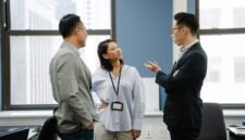 Tim karyawan sedang berdiskusi di sebuah ruang rapat modern, menunjukkan kolaborasi dalam menghadapi perubahan struktur perusahaan. Mereka terlihat fokus dan proaktif, mencerminkan semangat adaptasi dalam lingkungan kerja yang dinamis.