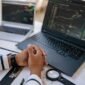 Seorang investor tampak serius menganalisis grafik saham di layar komputer, memikirkan strategi terbaik untuk menyikapi rencana *right issue* yang diumumkan oleh beberapa emiten. Gambar ini menangkap esensi pengambilan keputusan investasi yang cermat di tengah dinamika pasar modal.