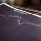 Seorang investor tengah menganalisis grafik saham di depan layar komputer, menggambarkan proses pengambilan keputusan investasi yang cermat menjelang periode stock split. Pergerakan harga dan volume perdagangan saham menjadi fokus utama dalam mencari peluang keuntungan.