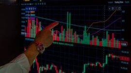 Seorang investor sedang menganalisis grafik pergerakan saham di layar, mencerminkan keputusan strategis yang diambil seputar jadwal stock split. Pemahaman yang mendalam terhadap data dan tren pasar adalah kunci dalam membuat keputusan investasi yang cerdas dan menguntungkan.