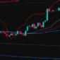 Seorang investor sedang menganalisis grafik saham di monitor, merefleksikan bagaimana keputusan buyback saham oleh perusahaan dapat memengaruhi pergerakan pasar dan nilai portofolionya.